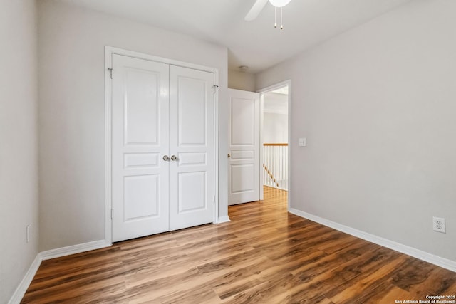 unfurnished bedroom featuring ceiling fan, a closet, and light wood-type flooring