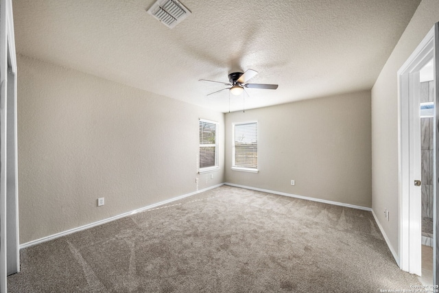 carpeted spare room with ceiling fan and a textured ceiling