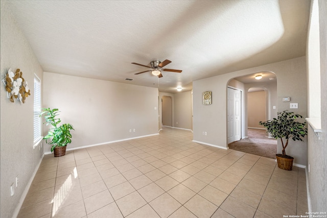 tiled empty room featuring ceiling fan and a textured ceiling