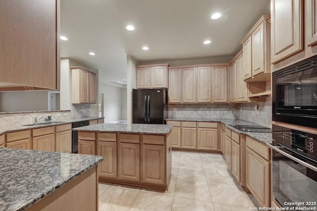 kitchen with light brown cabinetry, sink, light stone counters, and black appliances