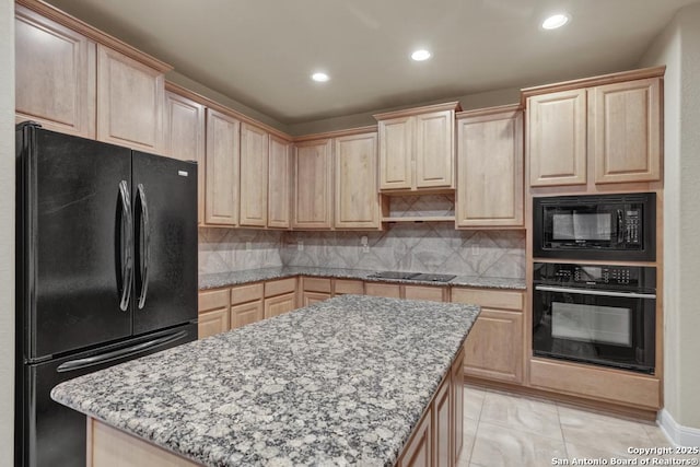 kitchen with light brown cabinetry, light stone countertops, black appliances, and a center island