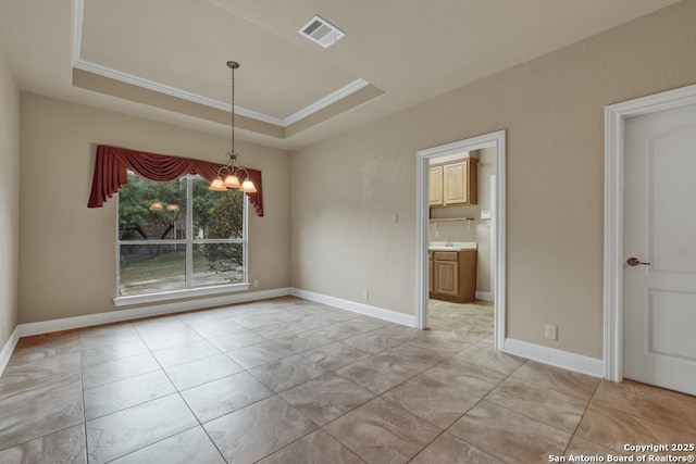 unfurnished room with crown molding, a tray ceiling, a chandelier, and sink