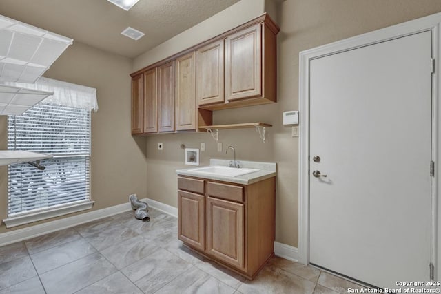 clothes washing area featuring cabinets, hookup for an electric dryer, sink, and washer hookup