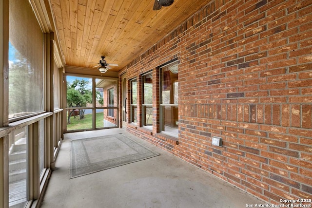 unfurnished sunroom with wooden ceiling and ceiling fan