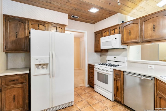 kitchen featuring light tile patterned floors, wooden ceiling, and white appliances