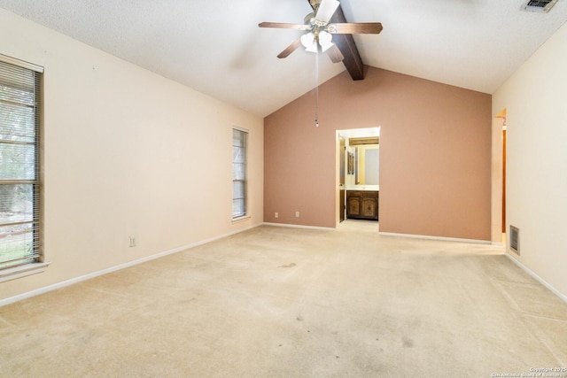 carpeted spare room with ceiling fan and vaulted ceiling with beams