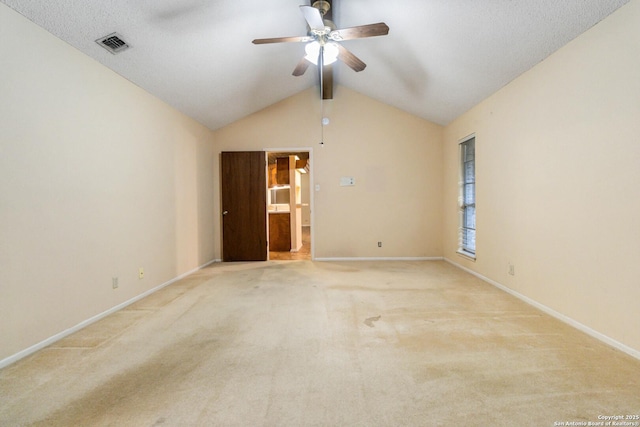 unfurnished room with ceiling fan, lofted ceiling, and light carpet