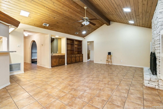 unfurnished living room featuring high vaulted ceiling, a fireplace, beamed ceiling, ceiling fan, and wood ceiling