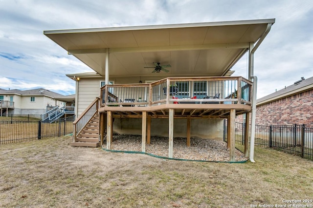 rear view of property featuring a yard, a deck, and ceiling fan