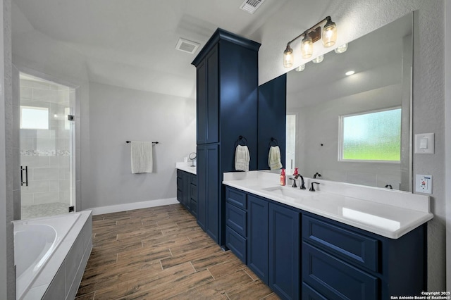 bathroom with vanity and shower with separate bathtub