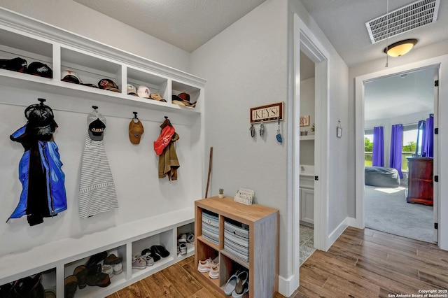 mudroom with hardwood / wood-style flooring and a textured ceiling