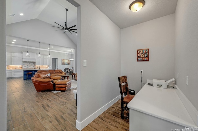 dining room with ceiling fan, lofted ceiling, sink, and light hardwood / wood-style floors