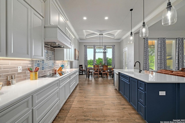 kitchen featuring hanging light fixtures, blue cabinetry, sink, and black electric cooktop