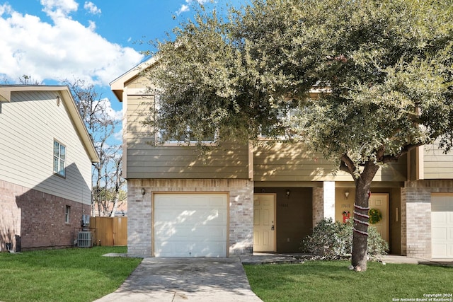 view of front facade with cooling unit, a garage, and a front yard