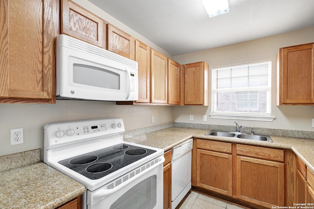 kitchen featuring sink, light tile patterned floors, and white appliances