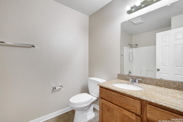 bathroom with walk in shower, vanity, toilet, and tile patterned flooring