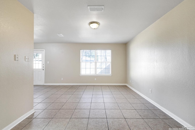 unfurnished room featuring a wealth of natural light and light tile patterned floors