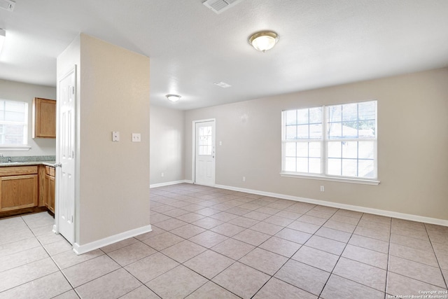 unfurnished living room with a healthy amount of sunlight and light tile patterned floors