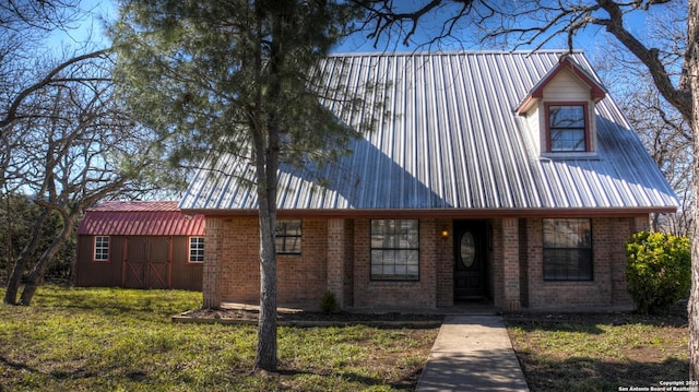 view of front of house with an outdoor structure and a front lawn