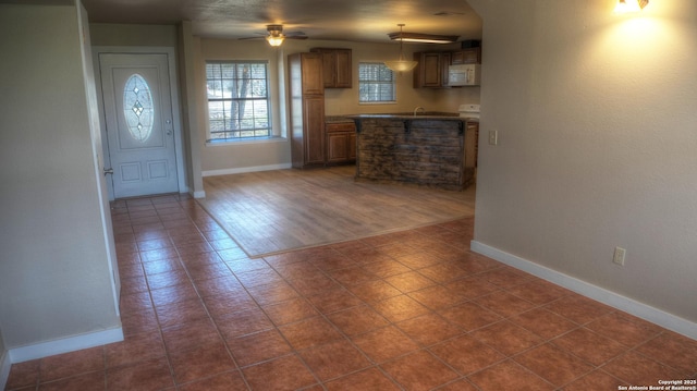 interior space featuring dark tile patterned floors and ceiling fan