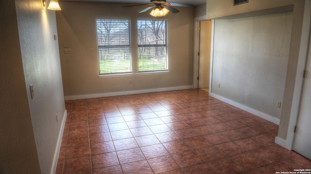 tiled empty room with ceiling fan and plenty of natural light