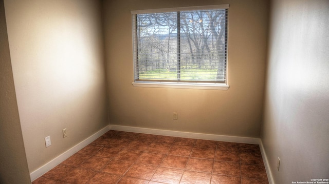 empty room with dark tile patterned floors