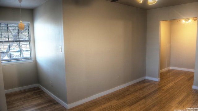 spare room featuring dark wood-type flooring and ceiling fan