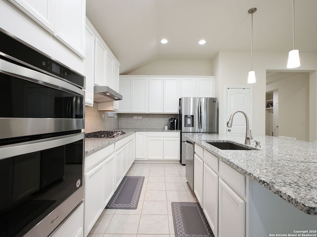 kitchen with sink, appliances with stainless steel finishes, white cabinets, light tile patterned flooring, and decorative backsplash