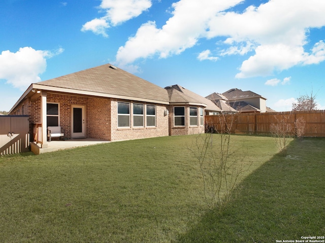 back of house with a lawn and a patio