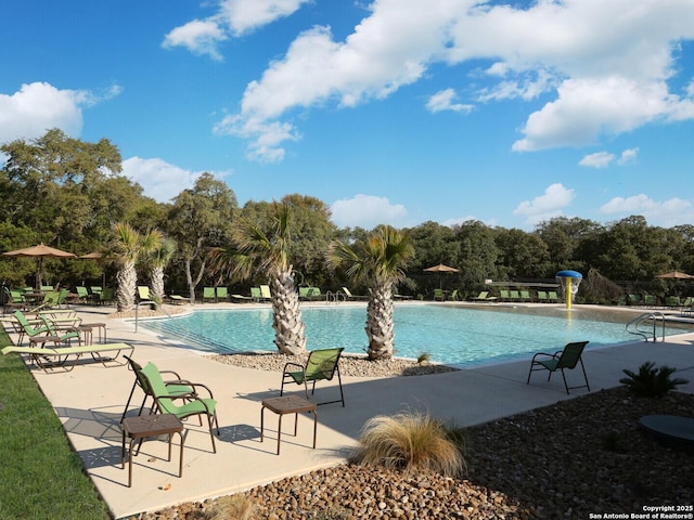 view of swimming pool featuring pool water feature and a patio