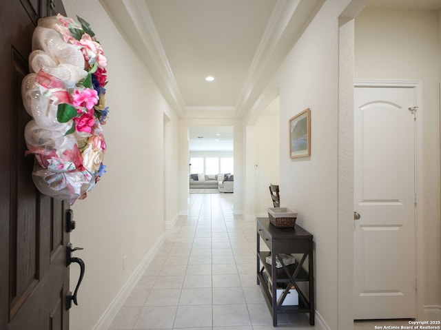 hall featuring light tile patterned flooring and crown molding