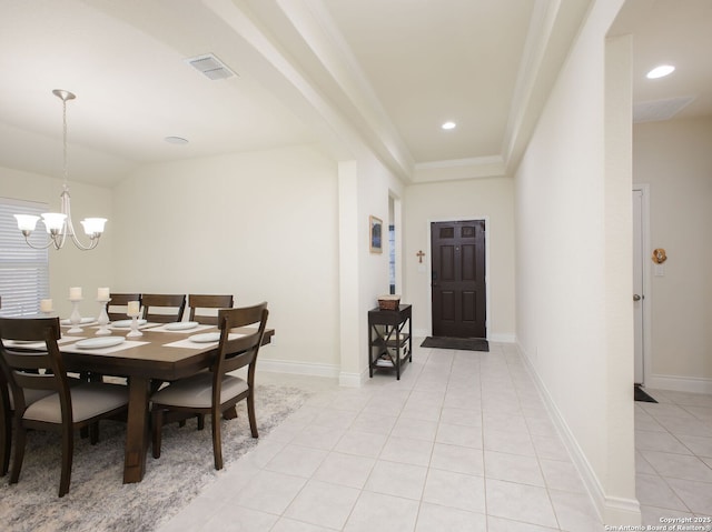 tiled dining space with vaulted ceiling and a chandelier