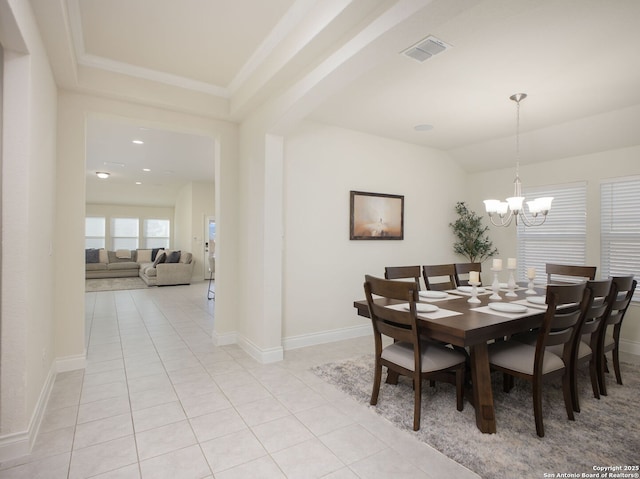 dining space with crown molding, a chandelier, and light tile patterned floors