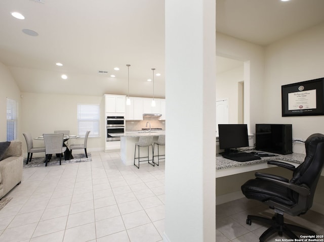 office area with light tile patterned flooring, sink, and built in desk