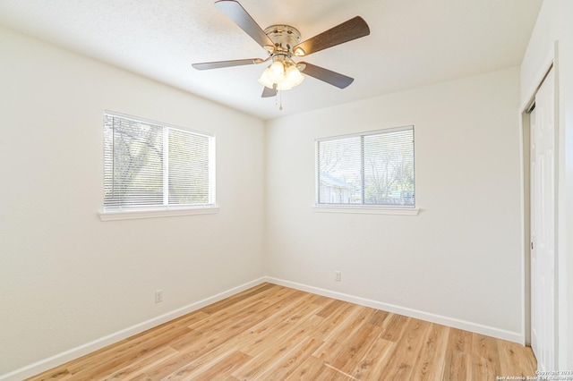 unfurnished bedroom featuring multiple windows, a closet, ceiling fan, and light wood-type flooring