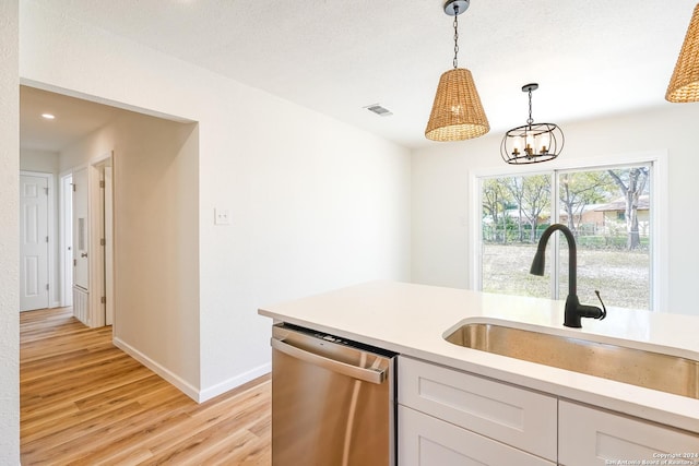 kitchen featuring sink, light hardwood / wood-style flooring, hanging light fixtures, dishwasher, and white cabinets