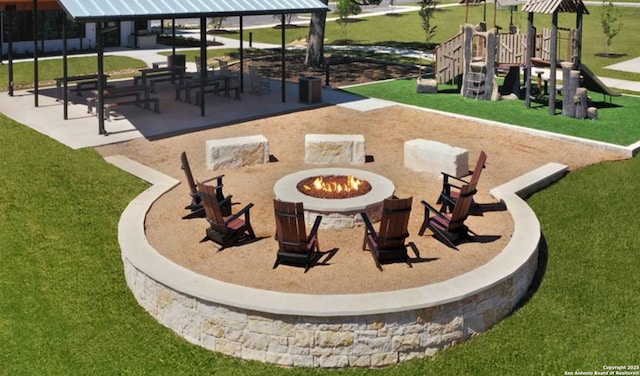 view of property's community featuring a playground and a fire pit