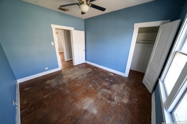 unfurnished bedroom featuring dark wood-type flooring, ceiling fan, and a closet