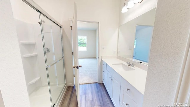 bathroom with vanity, wood-type flooring, and a shower with door