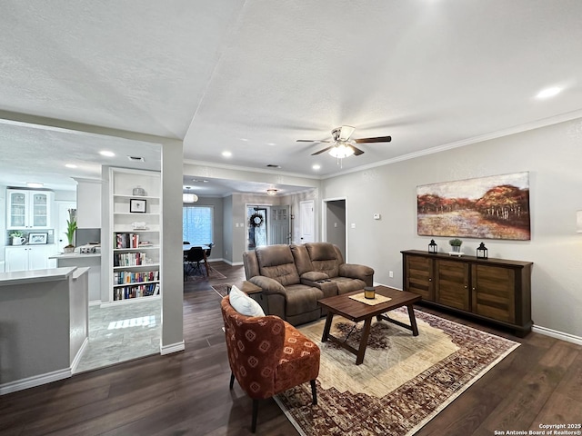 living room with baseboards, ornamental molding, dark wood-type flooring, a textured ceiling, and recessed lighting