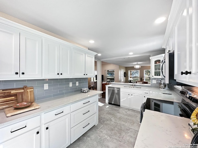 kitchen with stainless steel appliances, white cabinets, a sink, and backsplash