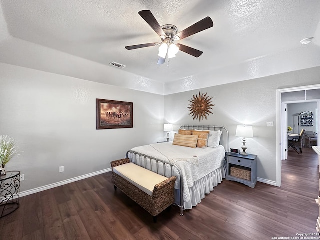 bedroom with a textured ceiling, wood finished floors, and visible vents