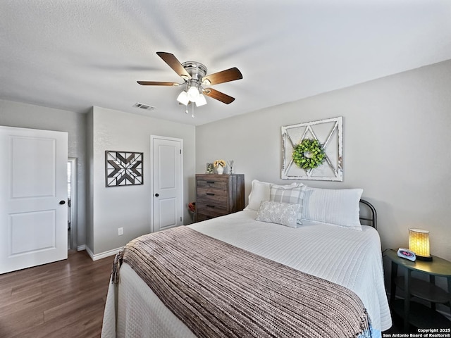 bedroom featuring dark wood-style flooring, visible vents, a ceiling fan, a textured ceiling, and baseboards