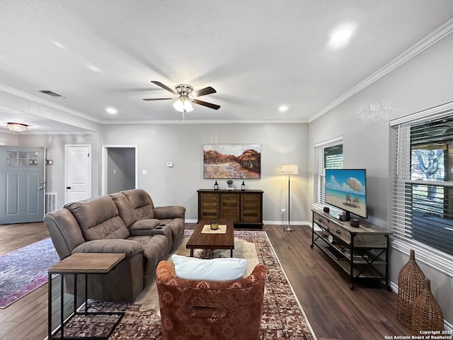 living area featuring visible vents, crown molding, baseboards, and wood finished floors