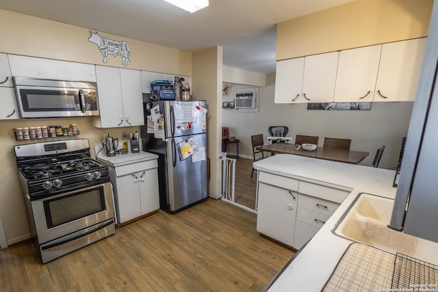 kitchen with sink, stainless steel appliances, dark hardwood / wood-style floors, a wall mounted AC, and white cabinets