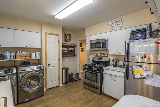 kitchen with white cabinetry, stainless steel appliances, dark hardwood / wood-style flooring, and separate washer and dryer