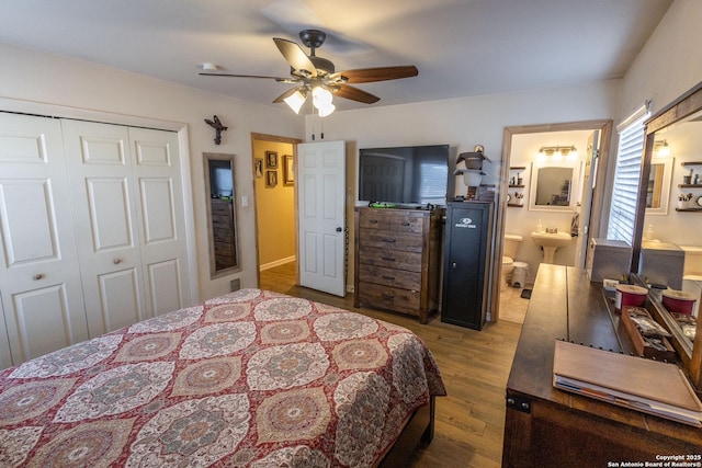 bedroom with ensuite bath, wood-type flooring, a closet, and ceiling fan