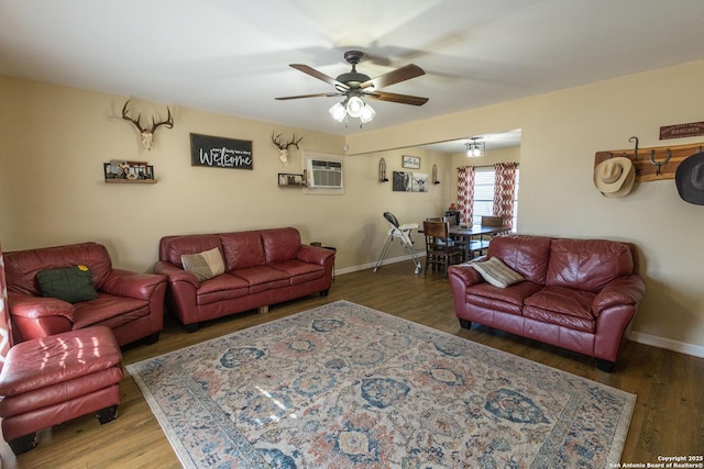 living room featuring dark hardwood / wood-style flooring, a wall unit AC, and ceiling fan