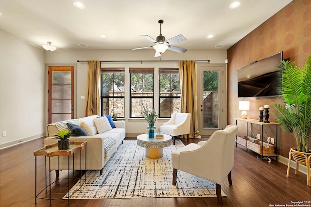 living room with dark wood-type flooring and ceiling fan