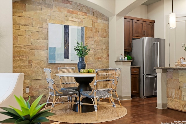 kitchen with dark wood-type flooring, stainless steel fridge, and pendant lighting